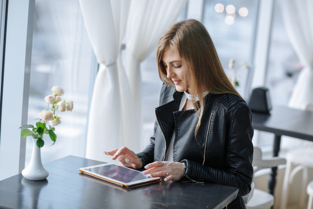 woman-sitting-restaurant-touching-tablet-scaled